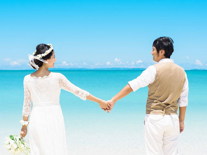海辺で結婚式を挙げるカップル